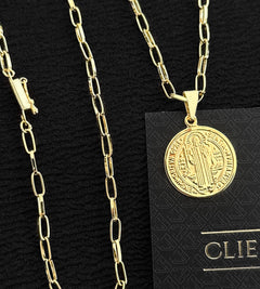 Corrente dourada com pingente redondo da medalha de São Bento, mostrando a figura do santo